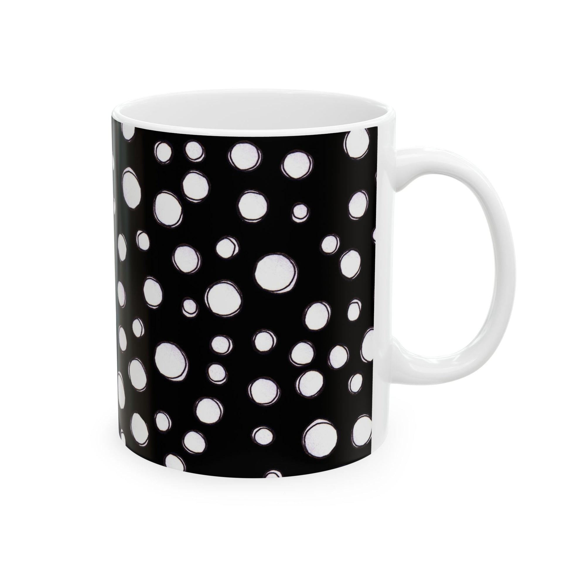 Black mug with white polka dots of varying sizes covering the entire surface.