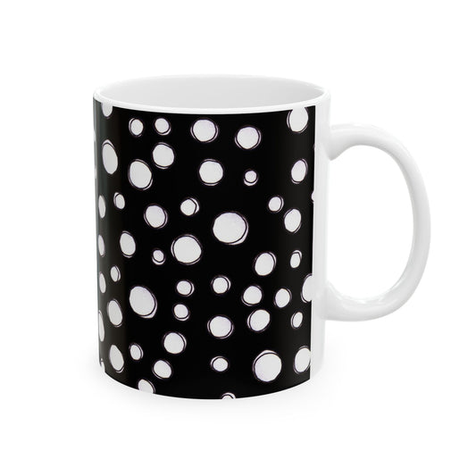 Black mug with white polka dots of varying sizes covering the entire surface.