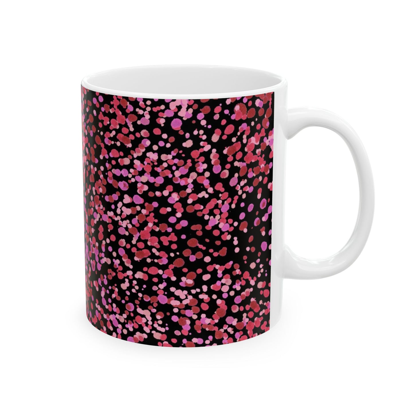 White mug with pink and red dots on a black background.
