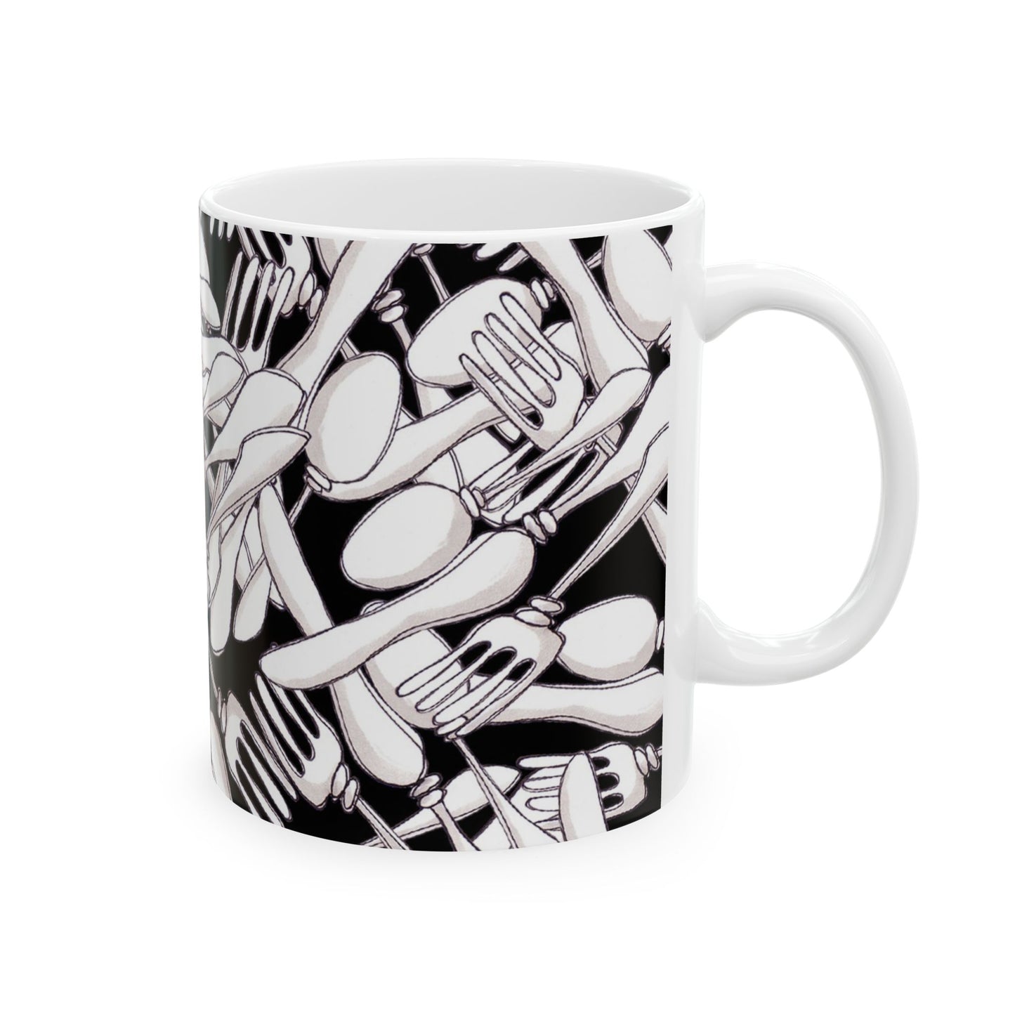 White mug with a black pattern of overlapping forks and spoons, creating a dense, abstract design.