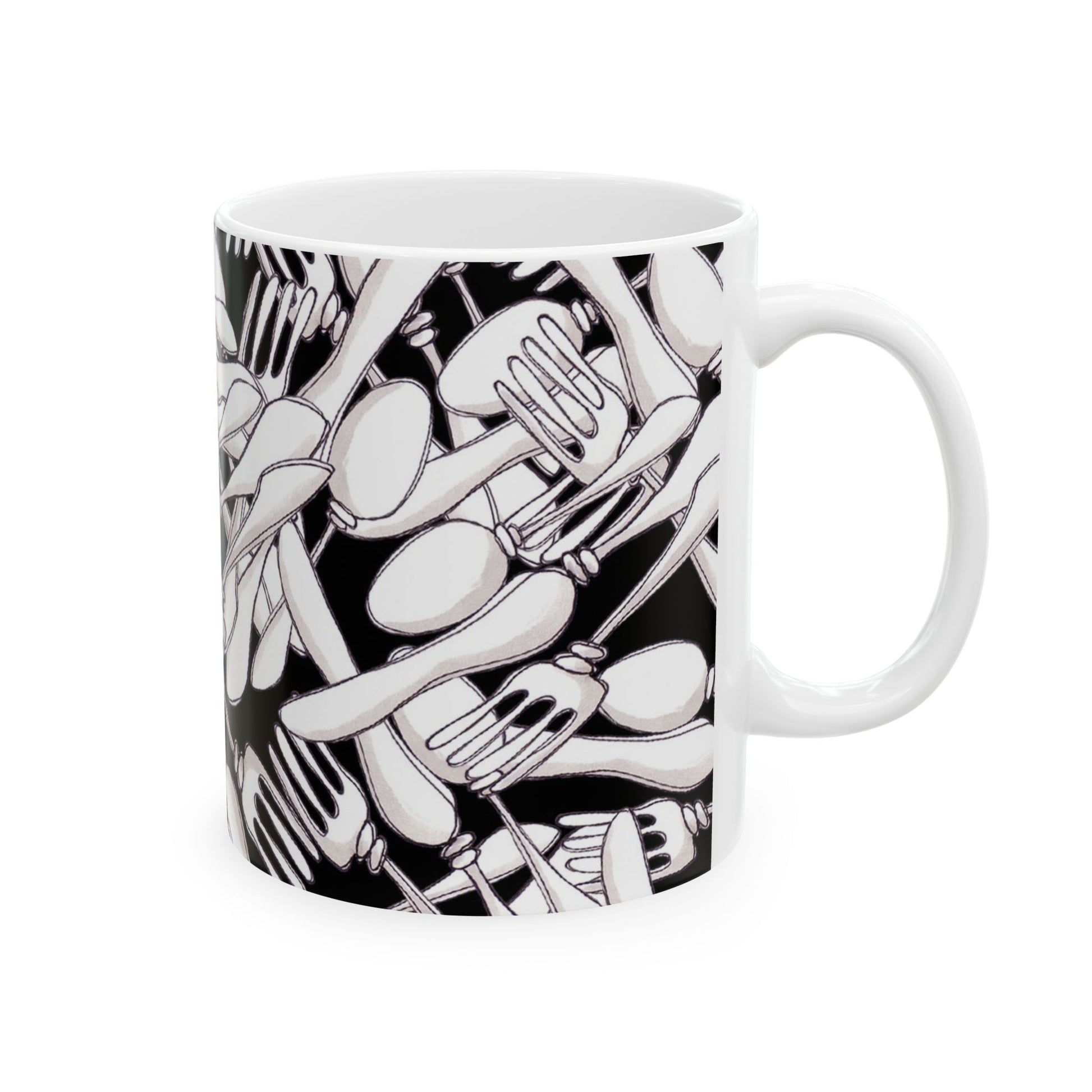 White mug with a black pattern of overlapping forks and spoons, creating a dense, abstract design.