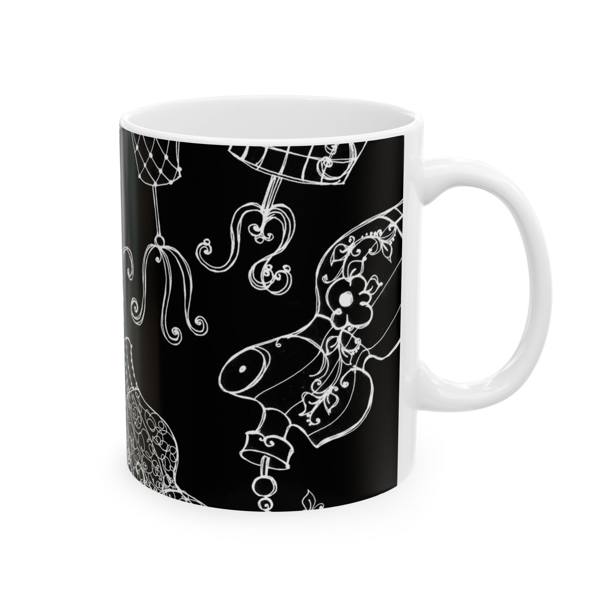 White mug with intricate white floral and abstract designs on a black background.