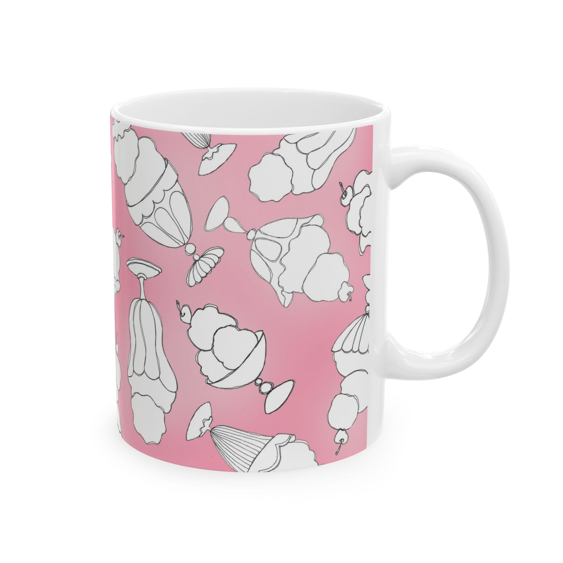 White mug with black outline dessert illustrations on a pink background.