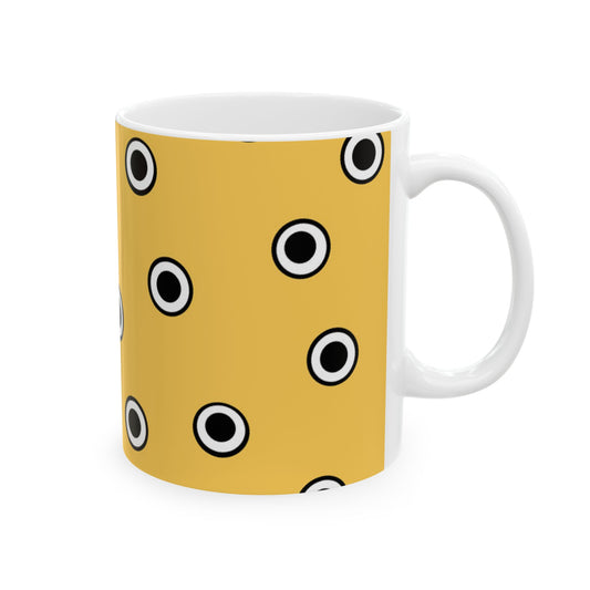Yellow mug with black and white polka dots, featuring a glossy finish and a white handle.