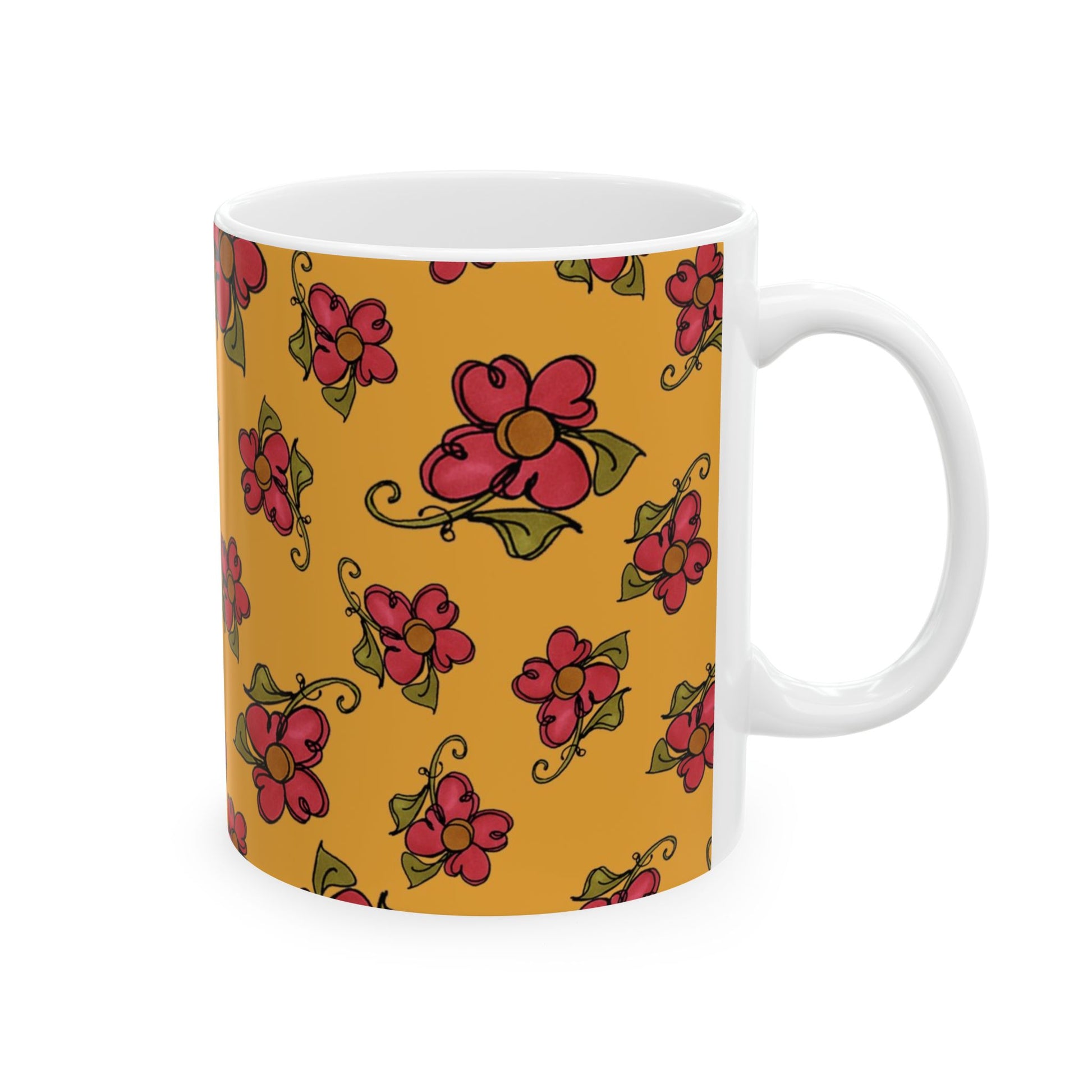 White mug with red flowers and green leaves on a mustard yellow background.