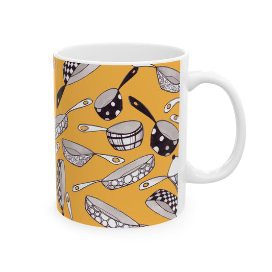 White mug with black and white cookware patterns on an orange background.
