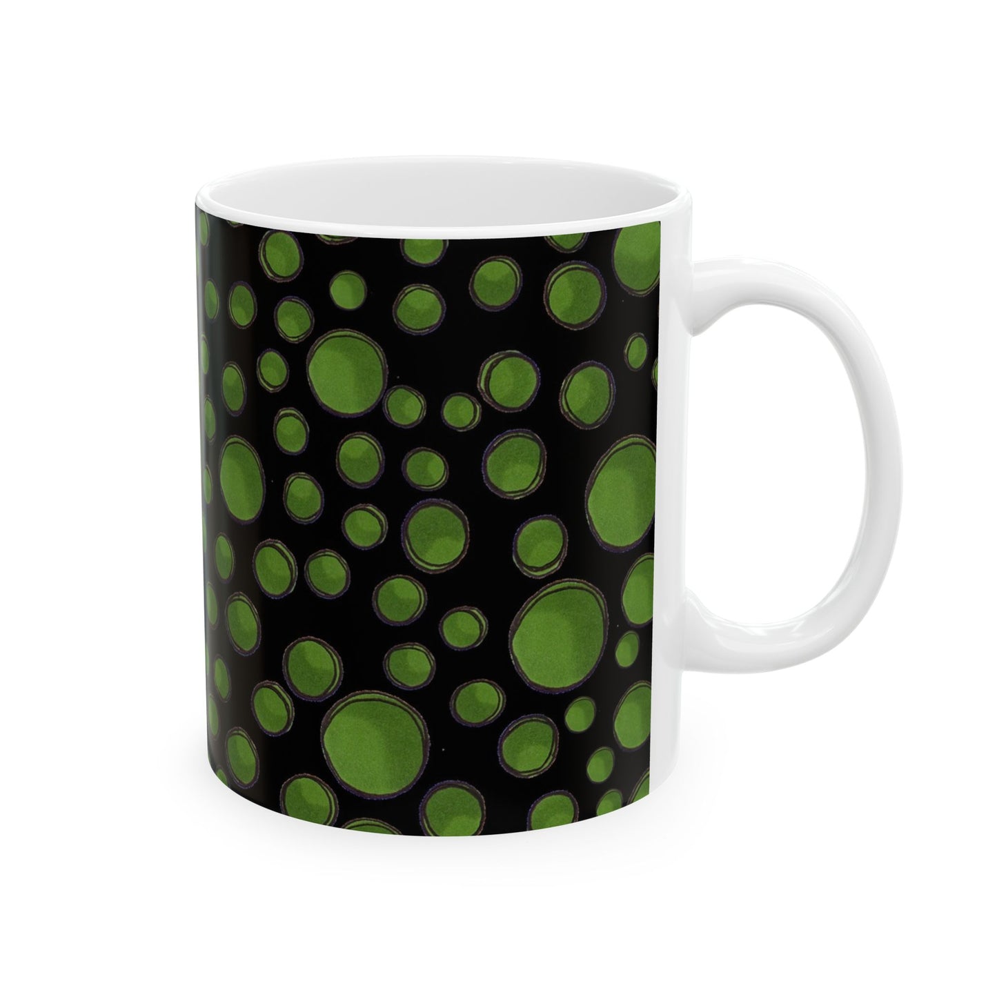 White mug with a black background and green circular patterns.