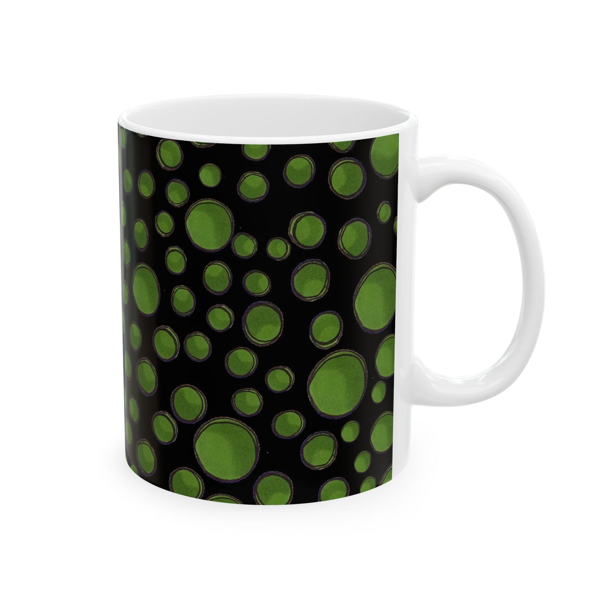 White mug with a black background and green circular patterns.
