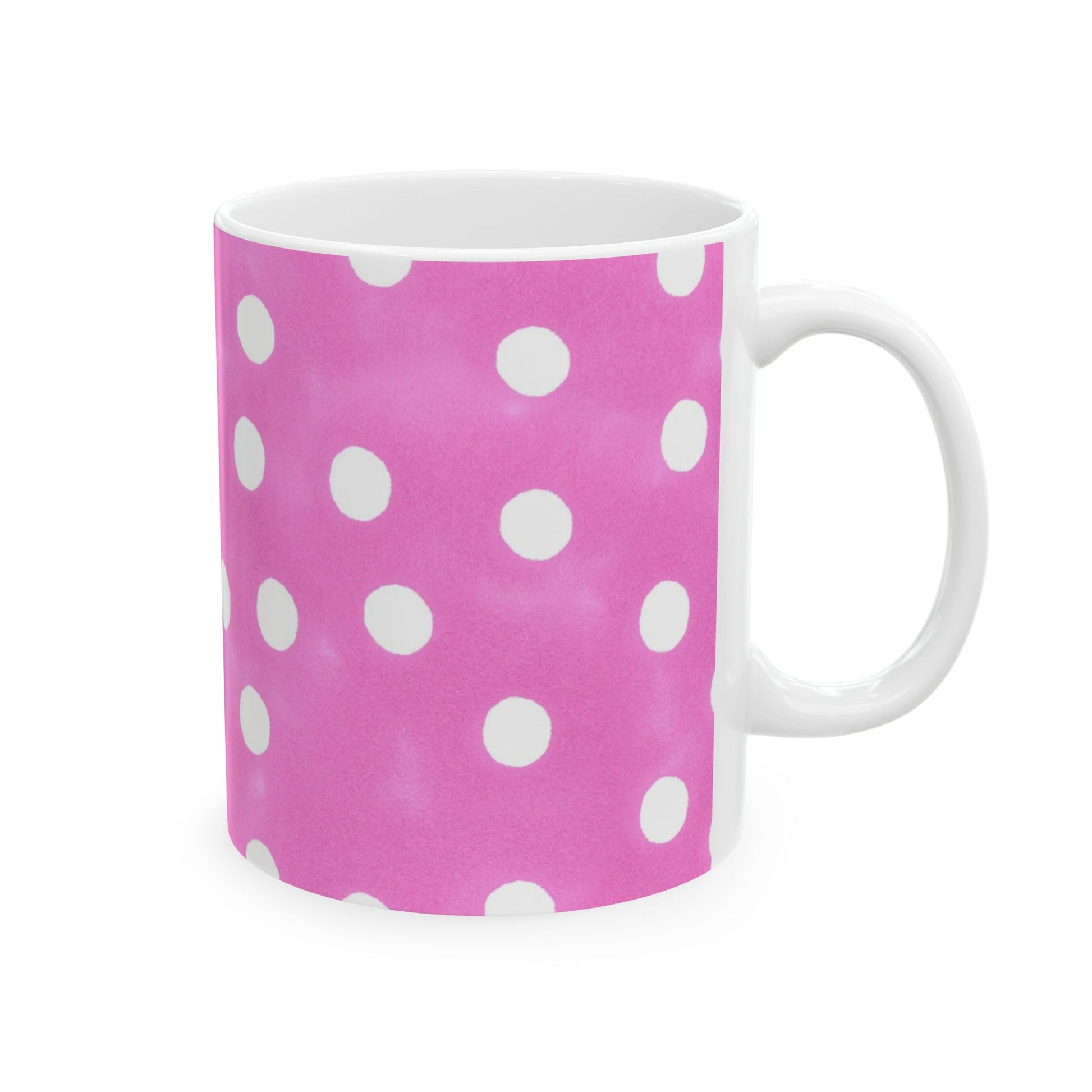 Pink mug with white polka dots and a white handle.