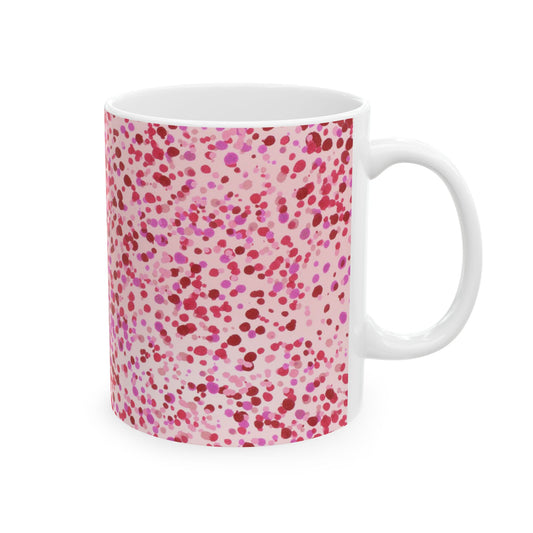 White mug with pink and red polka dots in varying sizes, scattered across the surface.