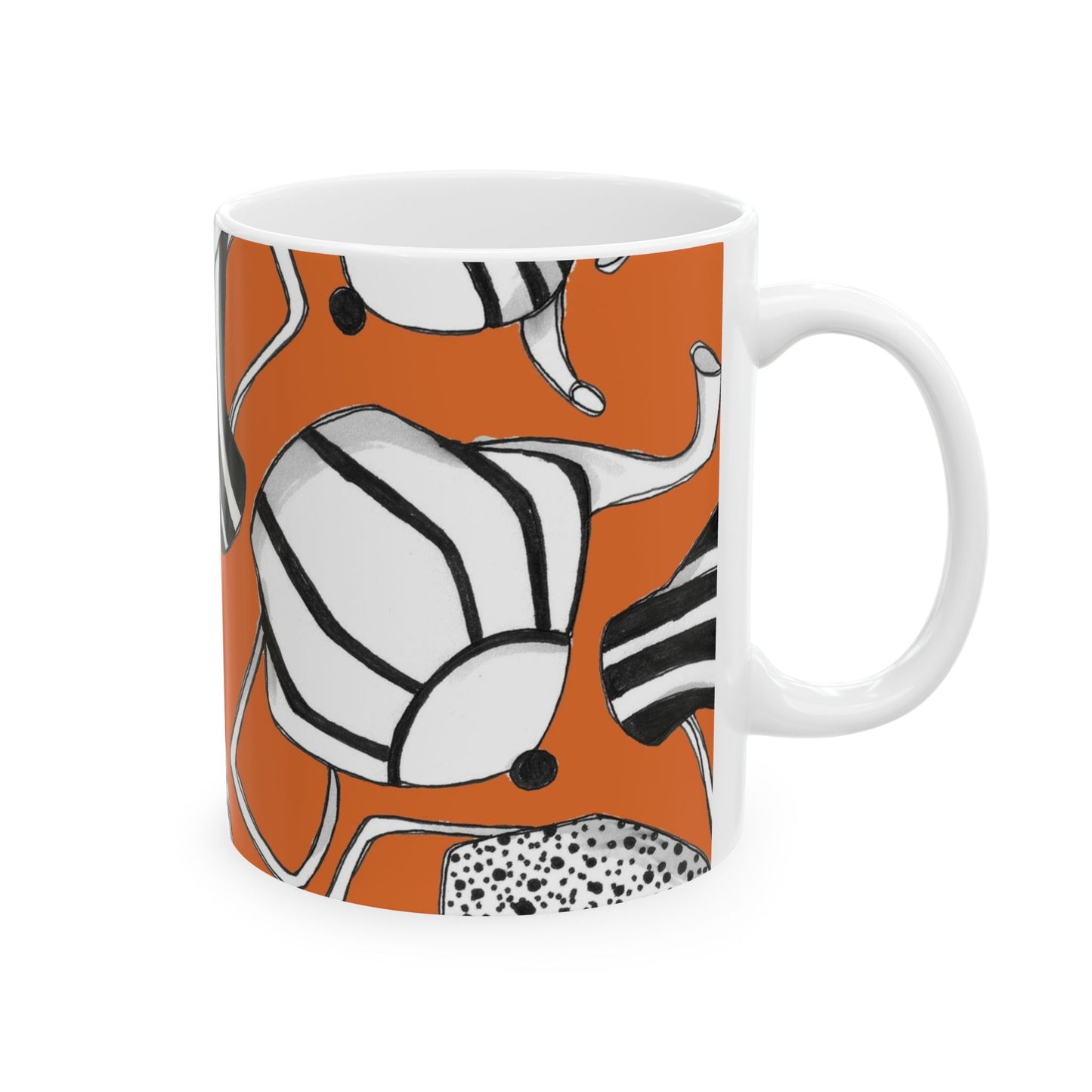 White mug with abstract black and white patterns on an orange background.