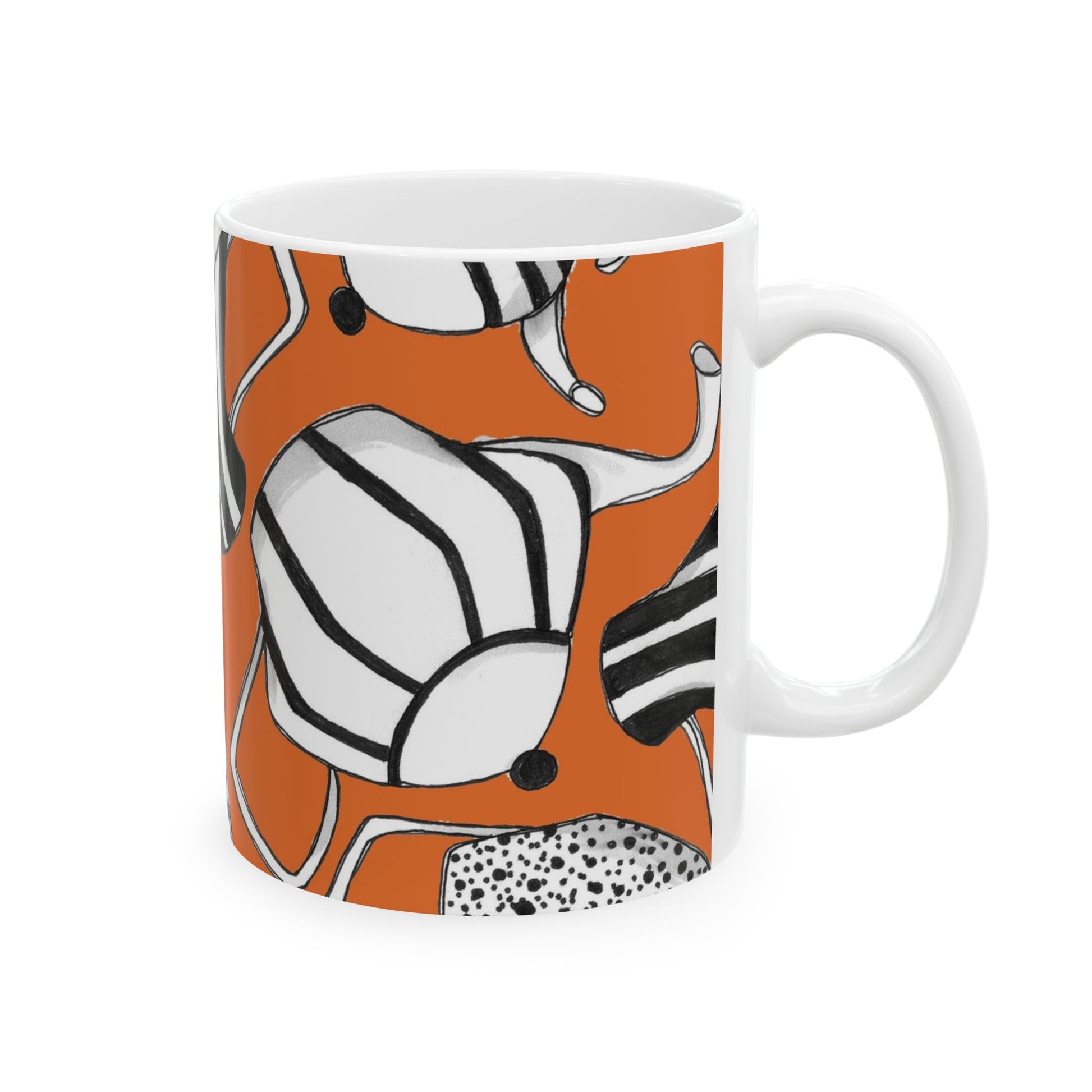 White mug with abstract black and white patterns on an orange background.