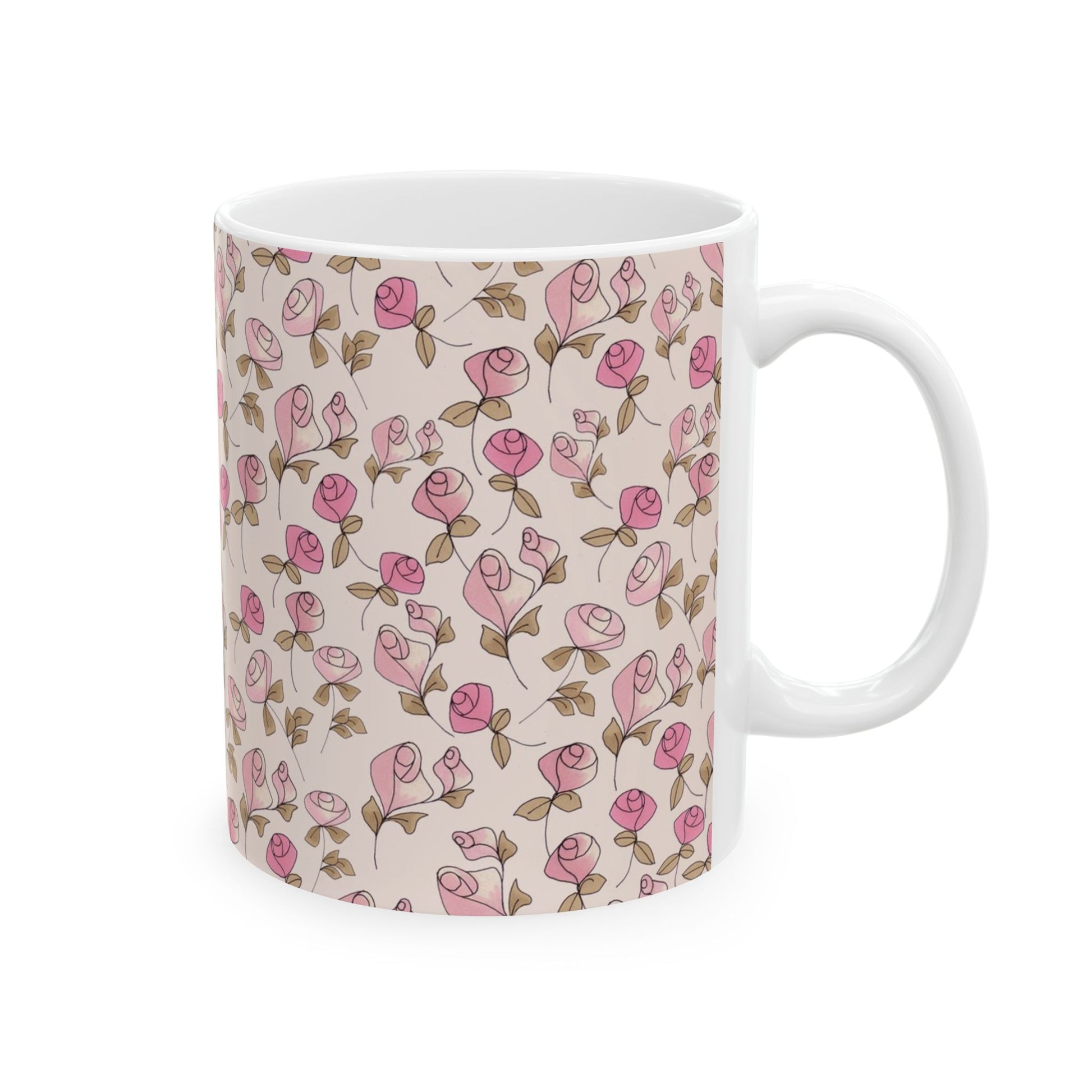White mug with pink rose pattern and brown leaves on a light beige background.