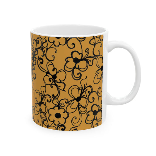 White mug with black floral pattern on an orange background.