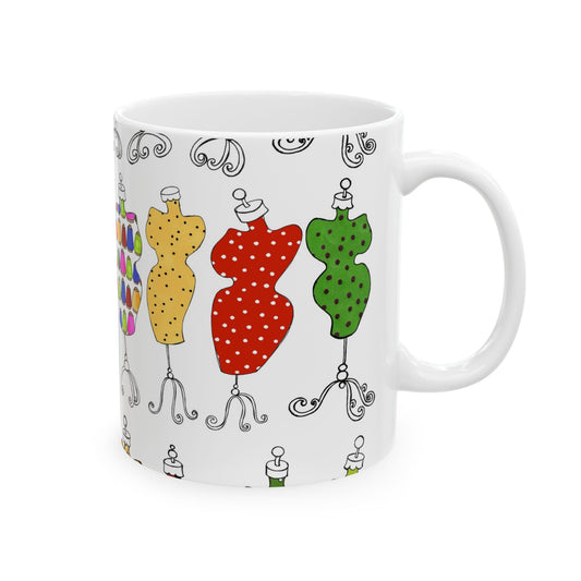 White mug with colorful dress forms in yellow, red, and green with polka dots and swirly bases.