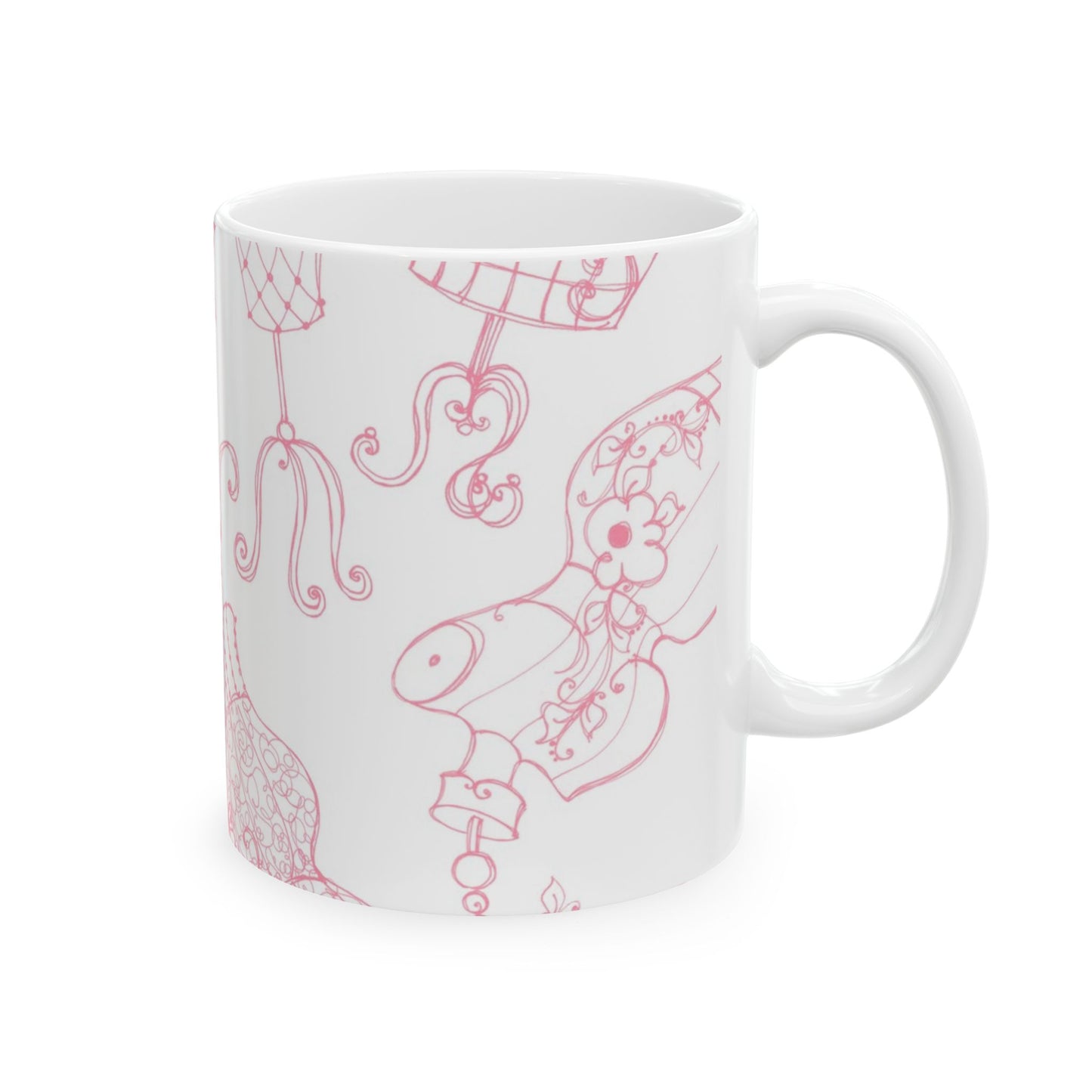White mug with pink, intricate line drawings of dress forms and floral patterns.