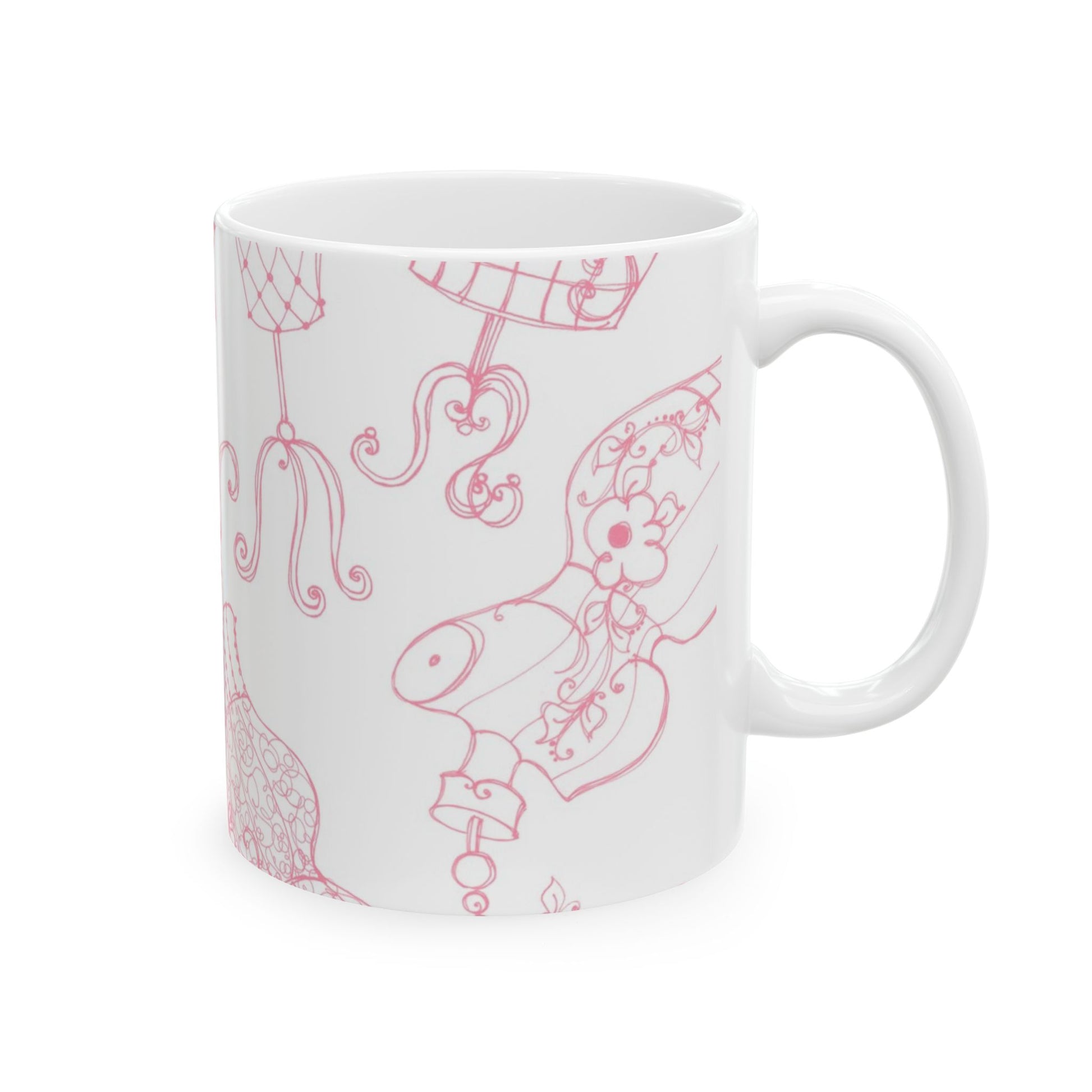 White mug with pink, intricate line drawings of dress forms and floral patterns.