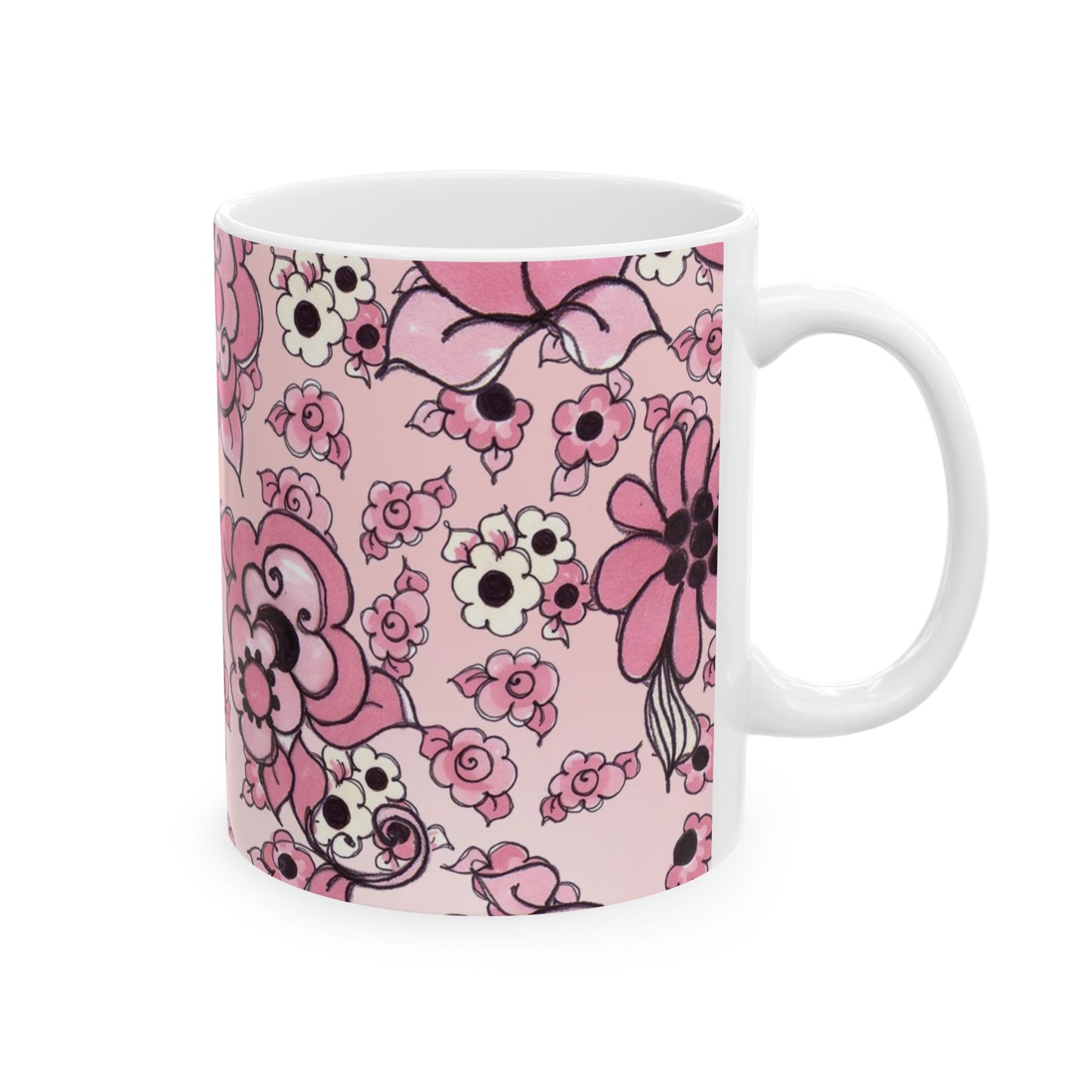 White mug with pink floral pattern, featuring various flowers and a bow on a pale pink background.