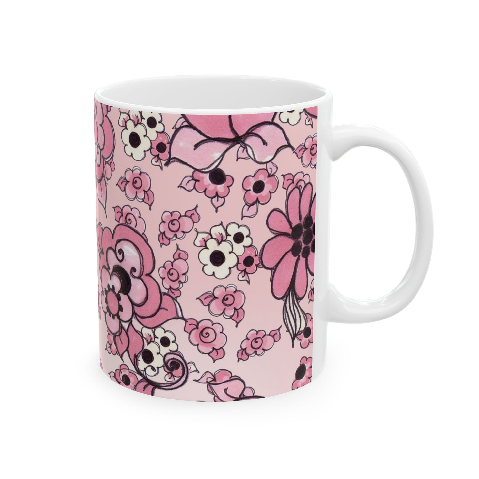 White mug with pink floral pattern, featuring various flowers and a bow on a pale pink background.