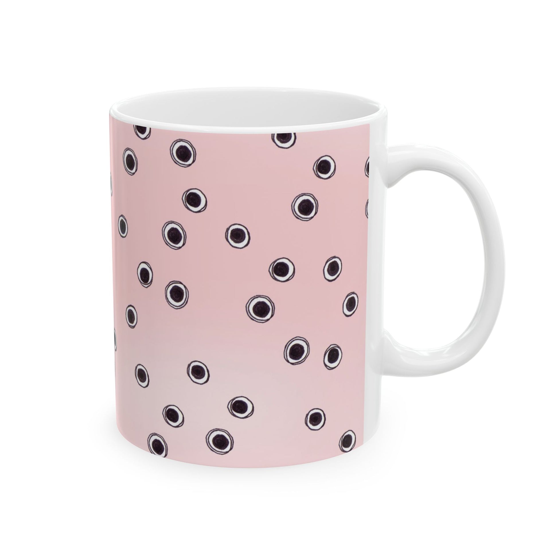 White mug with a pink background and scattered black and white circles pattern.