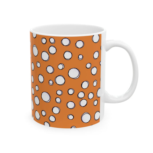White mug with an orange background and scattered white circles outlined in black.