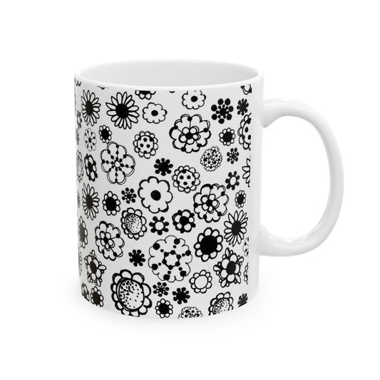 White mug with black floral pattern, featuring various flower shapes and sizes.