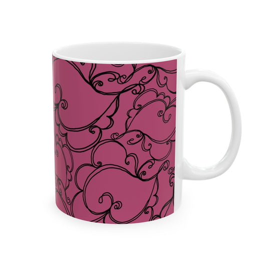 White mug with a pink background and black swirling floral patterns.