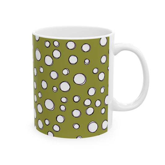 White mug with green background and white polka dot pattern.