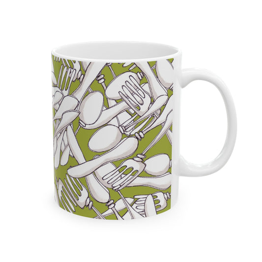 White mug with a green background, featuring a pattern of overlapping forks and spoons.