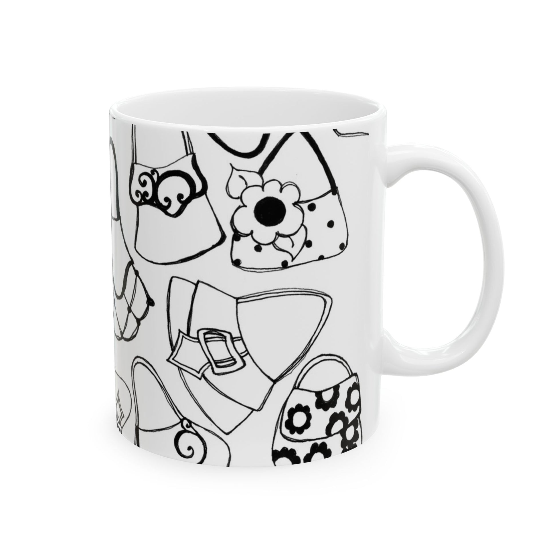 White mug with black outlined handbag designs, featuring floral and abstract patterns.