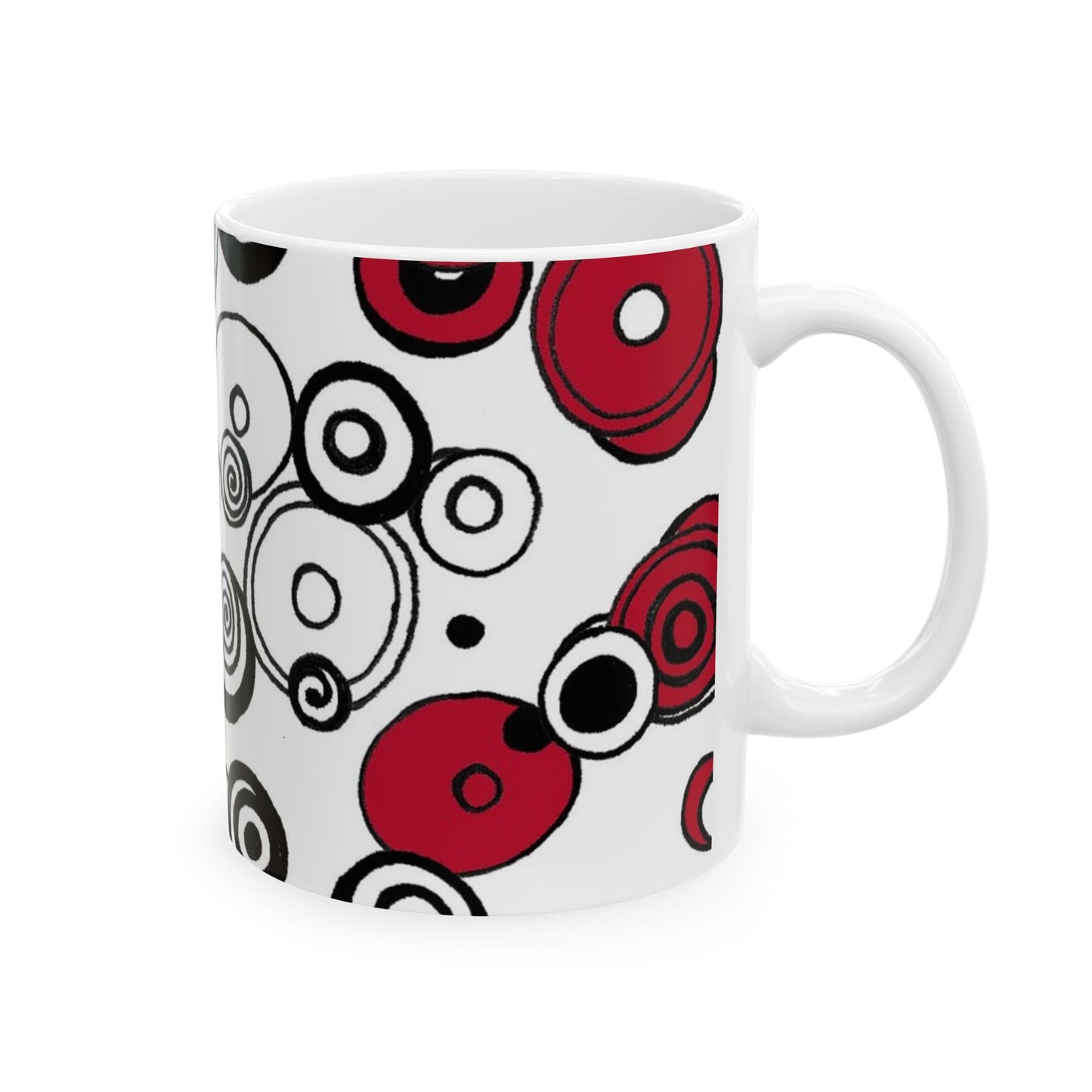 White mug with red and black concentric circle patterns on the exterior.