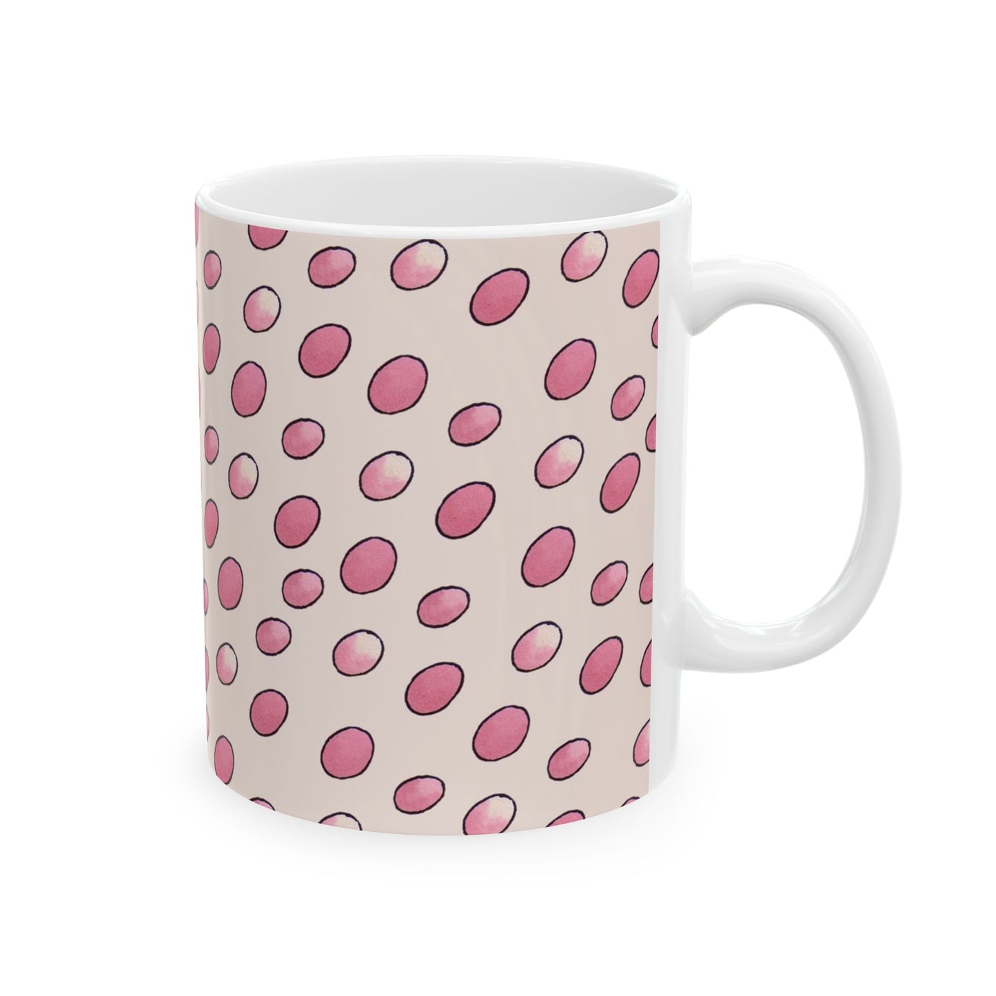 White mug with pink polka dots on a light beige background.