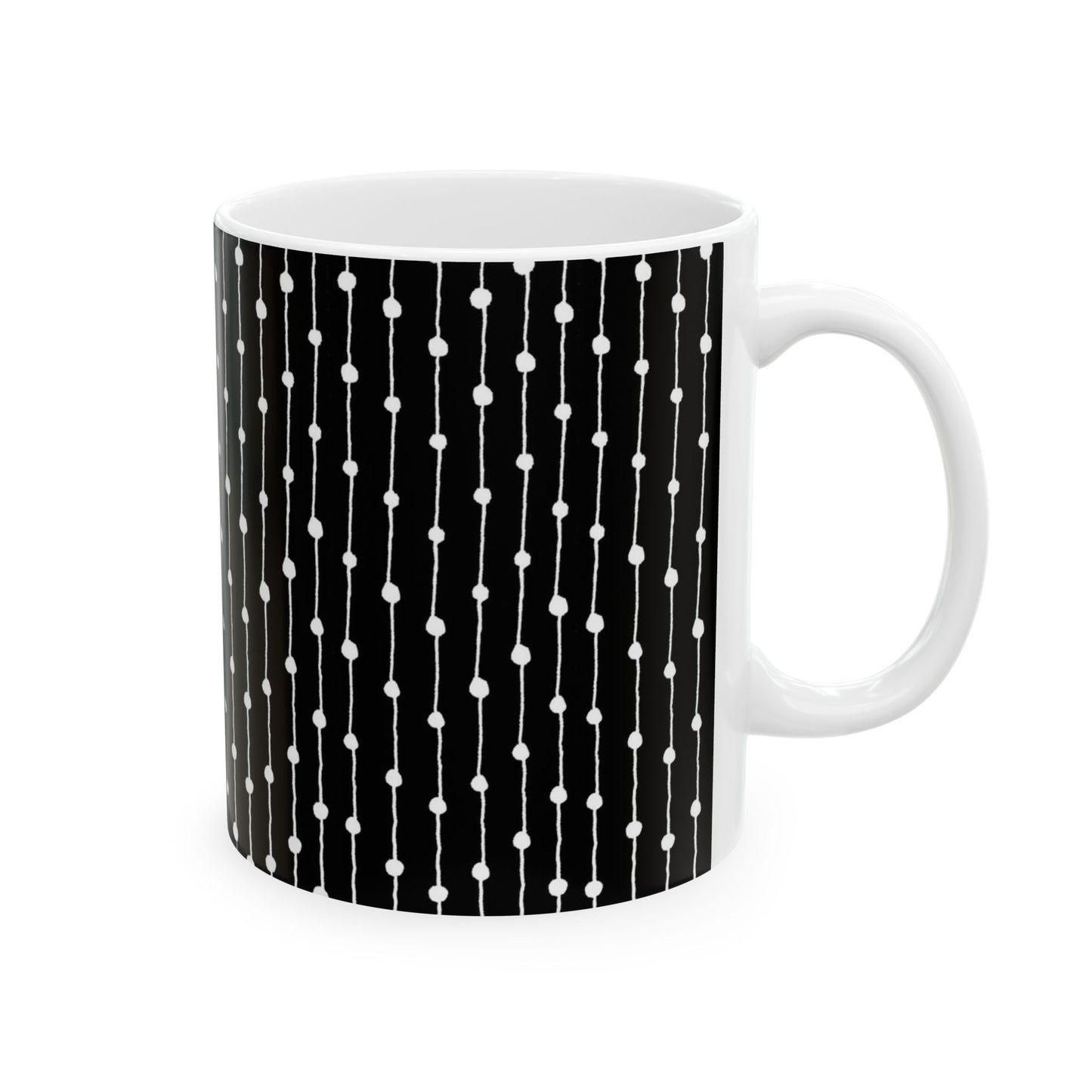 White mug with black background and vertical white lines with dots pattern.