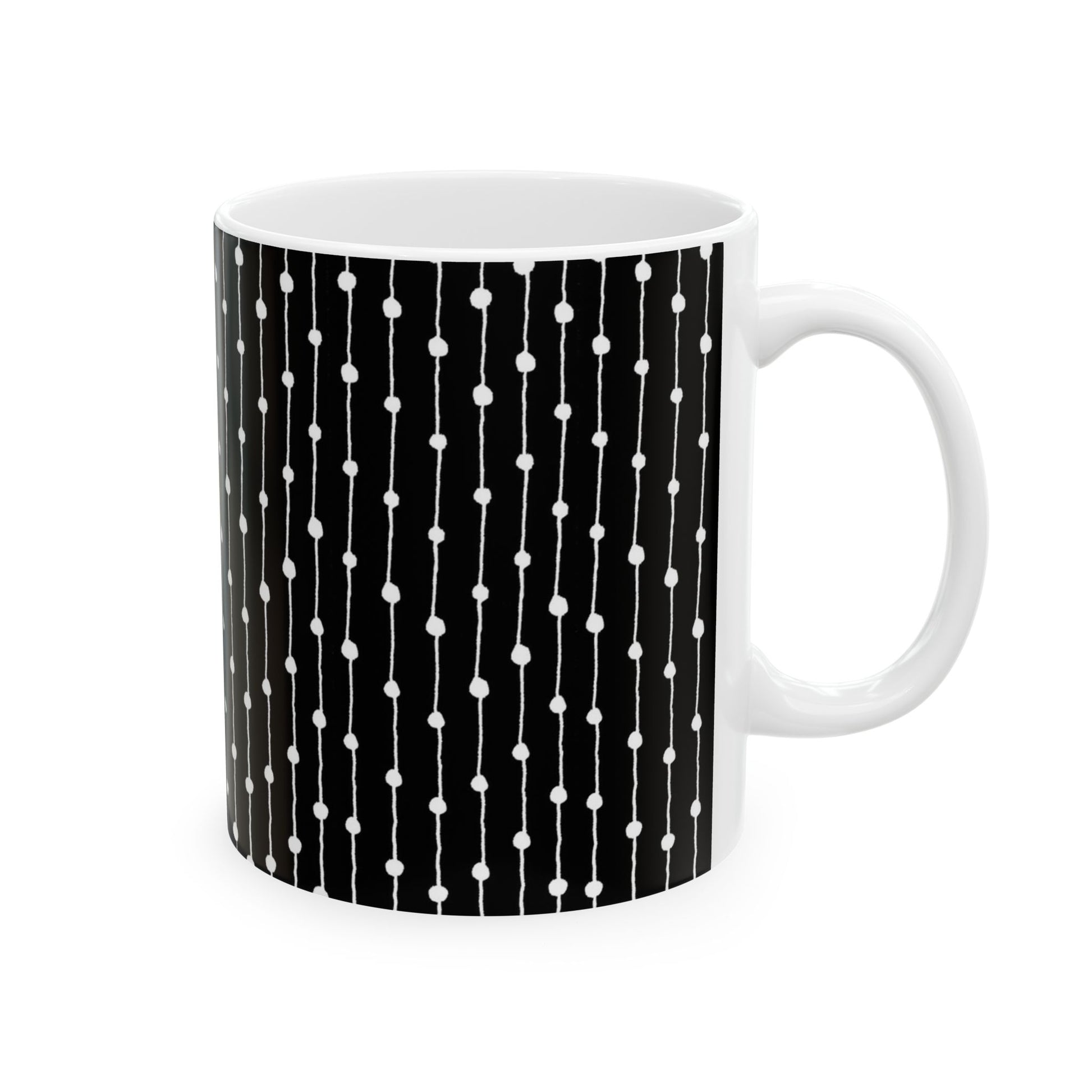 White mug with black background and vertical white lines with dots pattern.