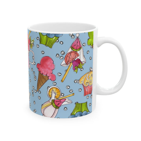 White mug with colorful desserts on a blue background, featuring cupcakes, ice cream, and lollipops.